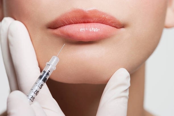 Woman receiving lip filler injection