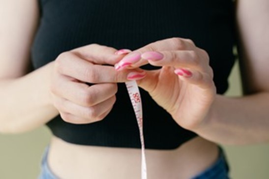 Woman with measuring tape after liposuction alternative treatment