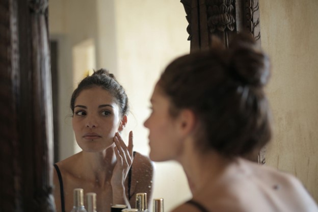 woman looking in mirror at scars